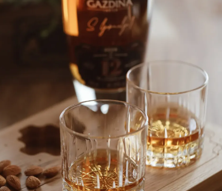 kristalne case sa odlzalom sljivovicom na drvenom stolu